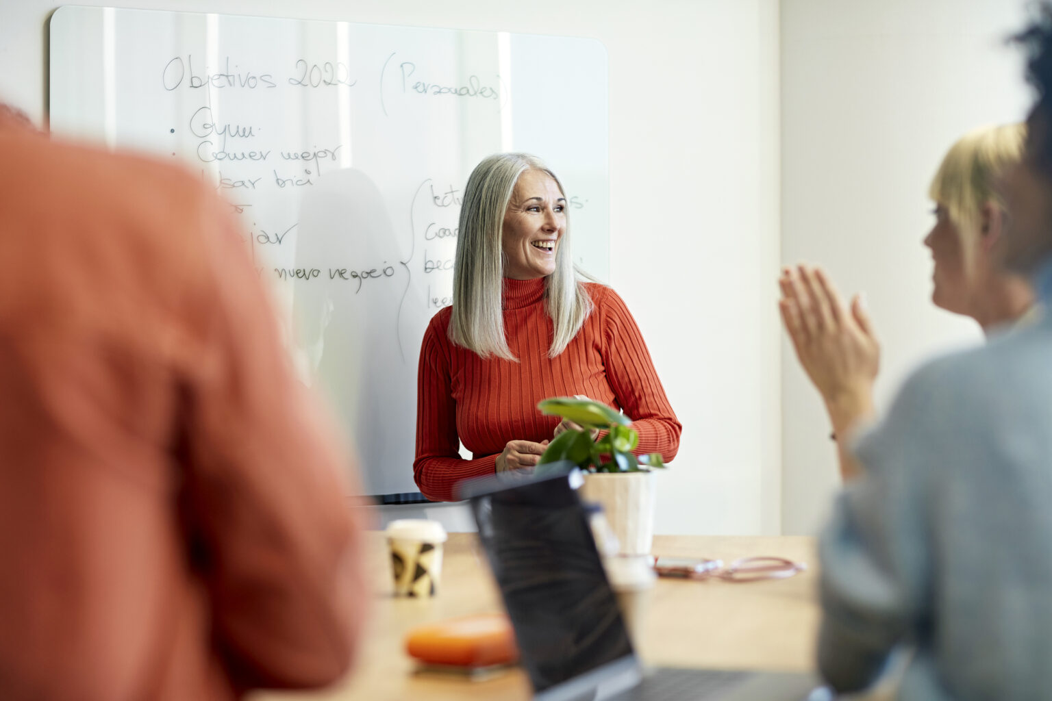 Woman receives applause from colleagues for her ideas at informal meeting.