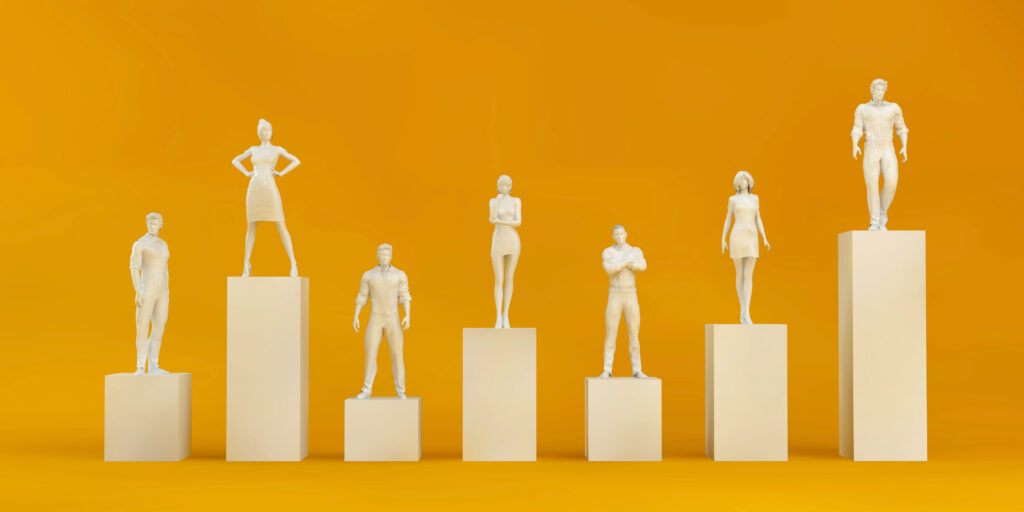 A group of male and female statues standing on top of podiums that vary in height
